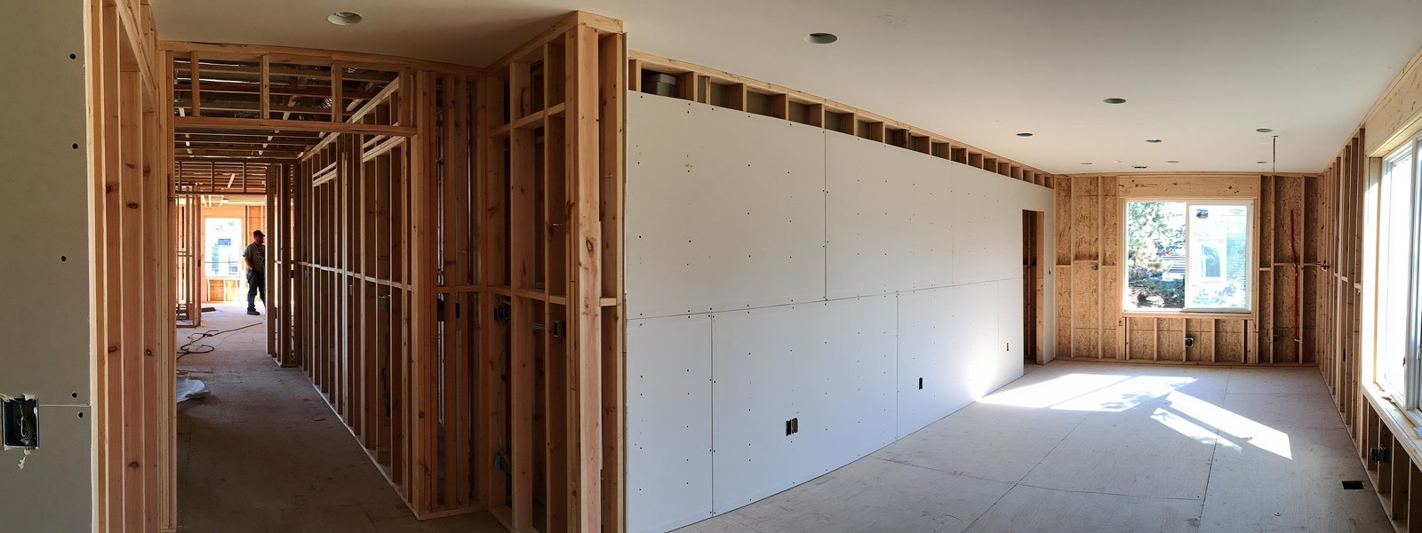 Wide view of a room with new board hung and taped