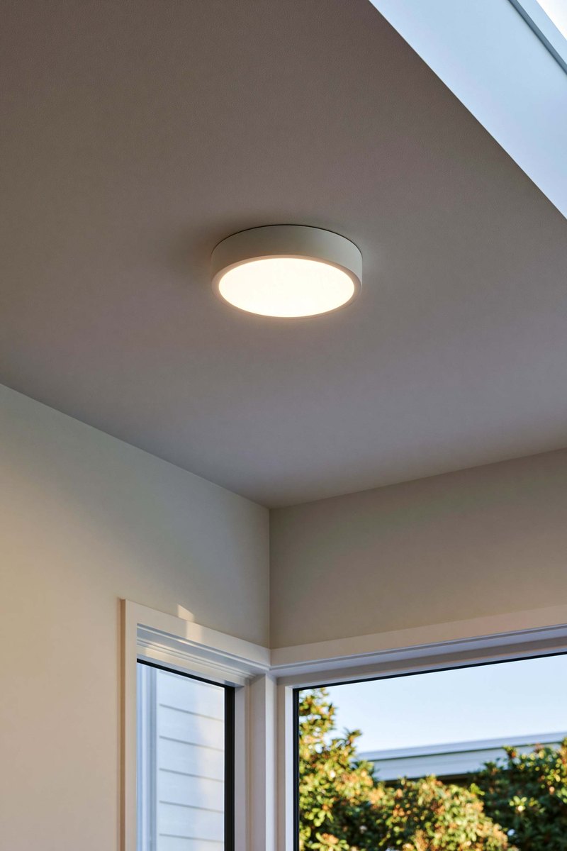 Smooth ceiling with a round flush light fixture, seen from below